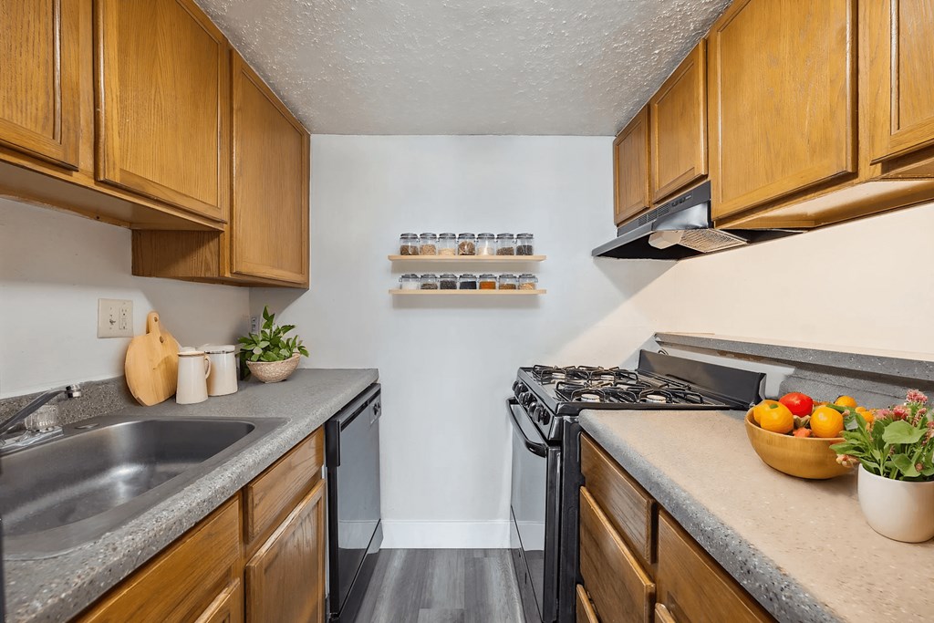 A kitchen with wooden cabinets and a black stove top.