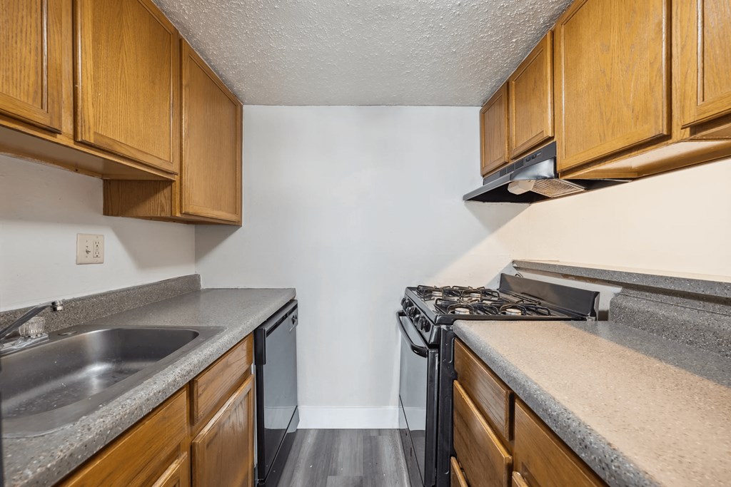 A kitchen with wooden cabinets and a black stove top oven.