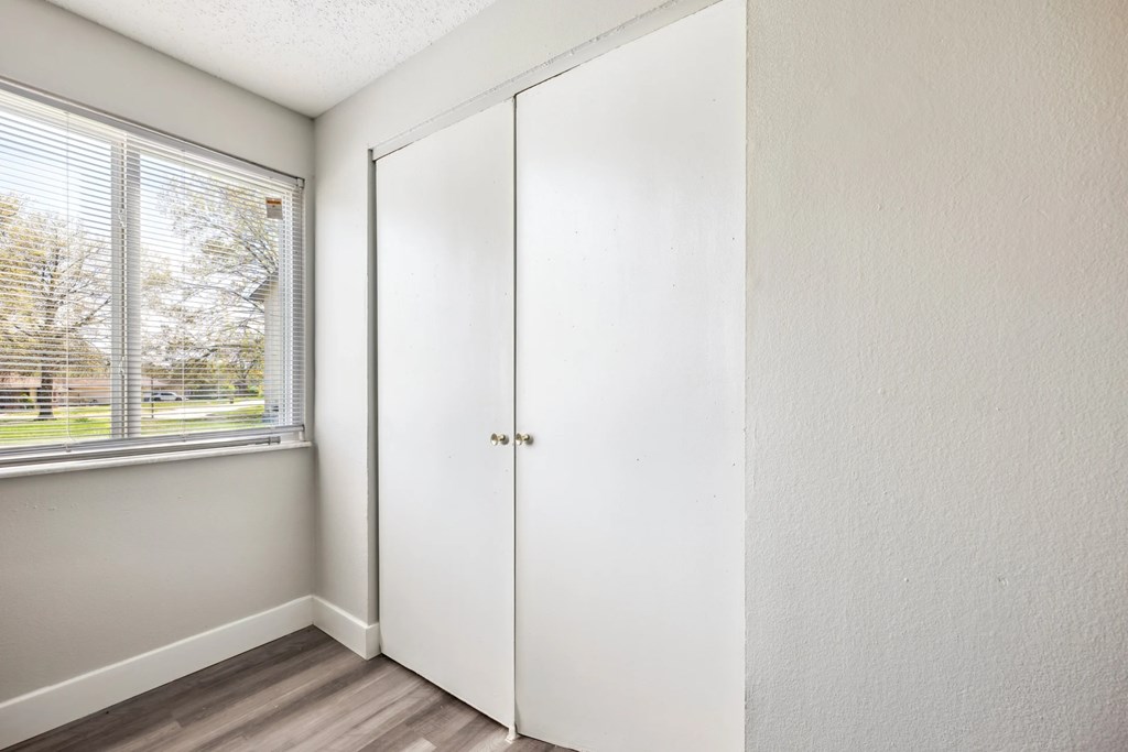 A white door is in a room with a window.