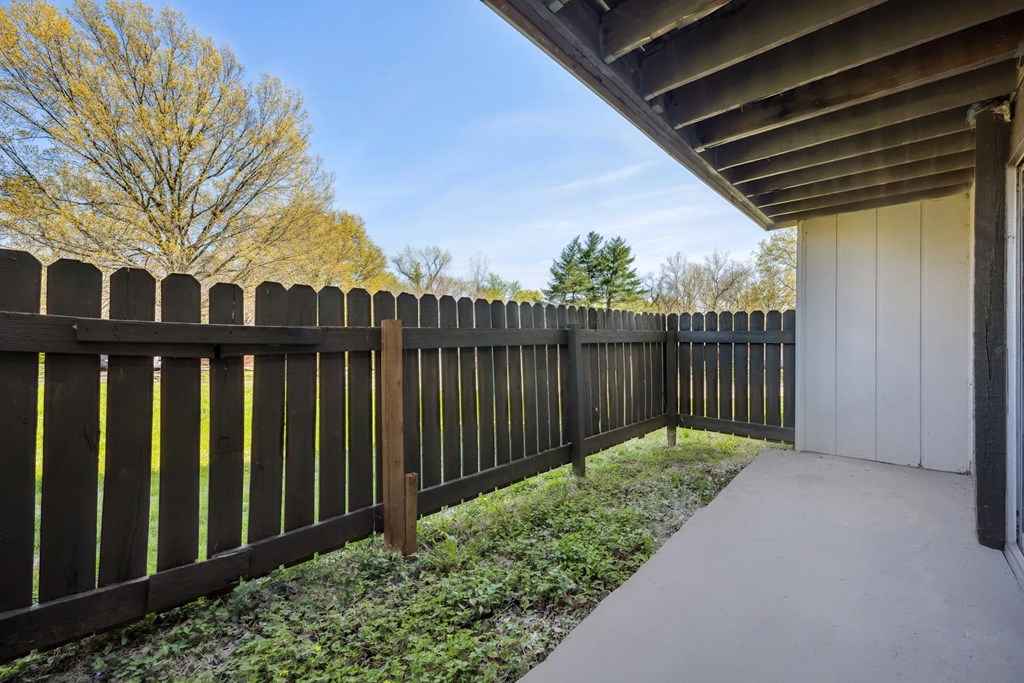A wooden fence runs along the side of a concrete path.