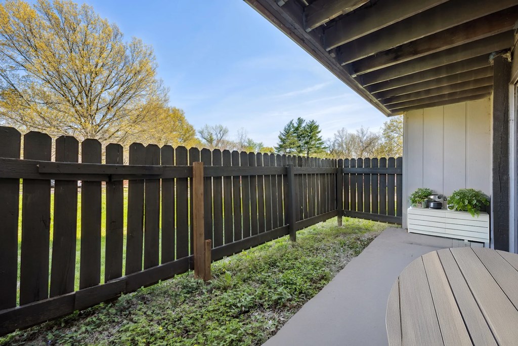A wooden fence runs along the side of a house.
