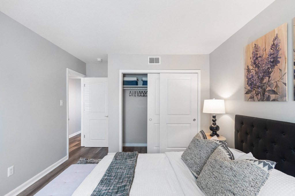 A bedroom with a large bed and a painting on the wall.