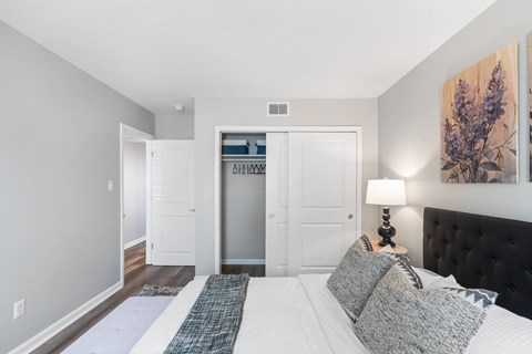 A bedroom with a large bed and a painting on the wall.