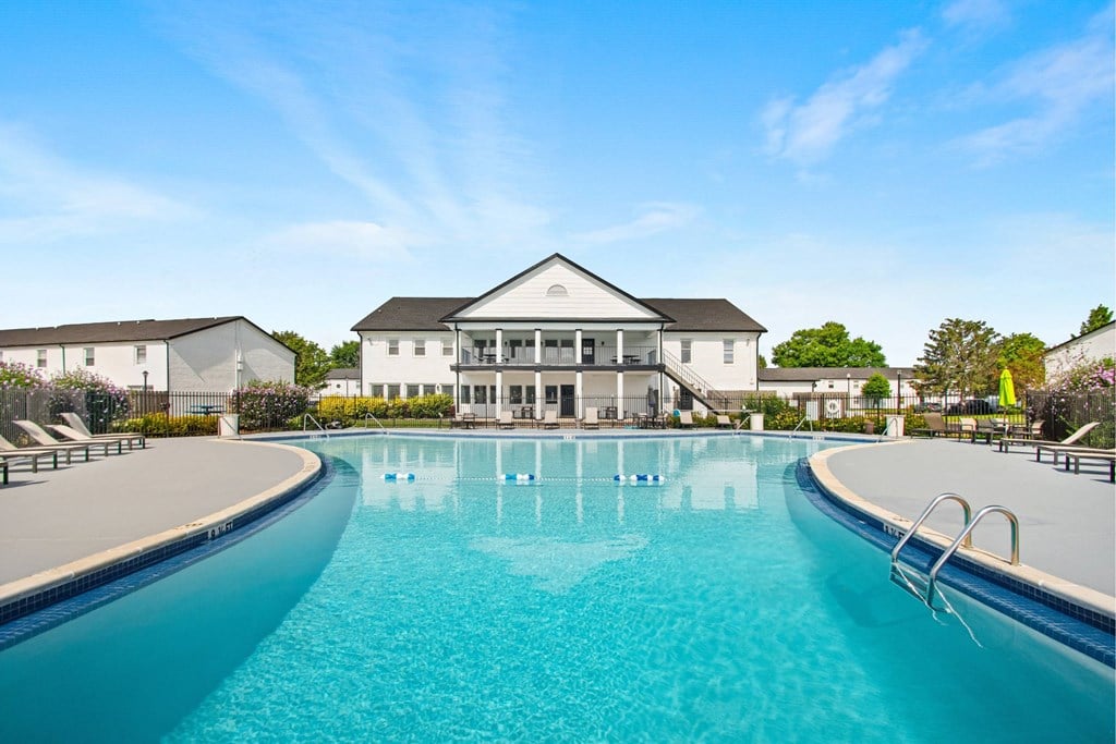 A large swimming pool in front of a white building.