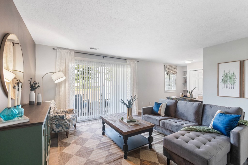 A living room with a grey couch and a wooden coffee table.