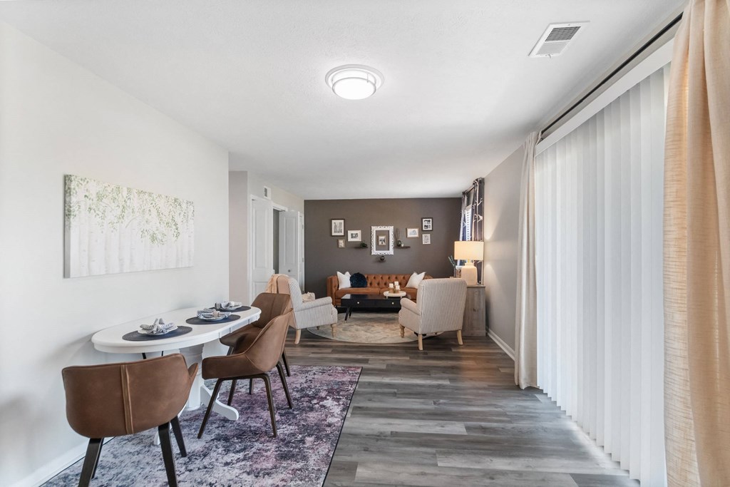 A dining room with a white table and brown chairs.