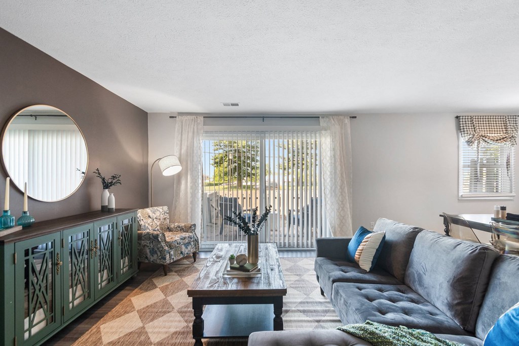 A living room with a grey couch, a wooden coffee table, and a green cabinet.