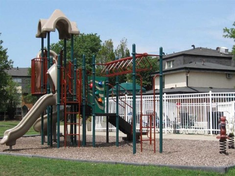 A playground with a green and red slide.