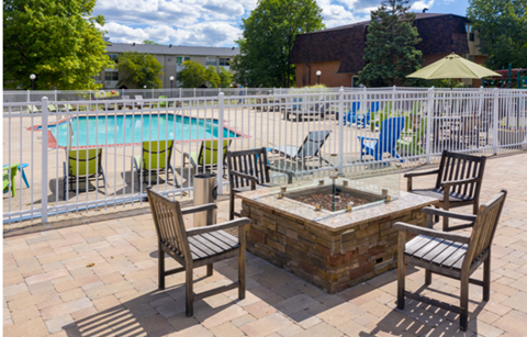 A pool area with a table and chairs.