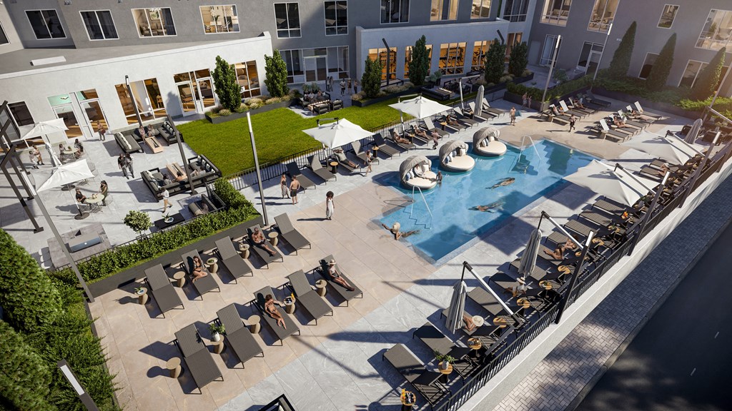 an aerial view of the resort style pool with lounge chairs and umbrellas