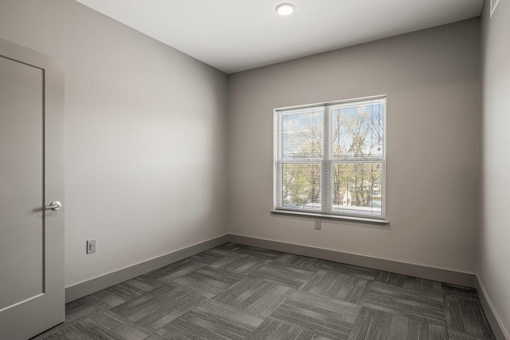 an empty room with a window and a door