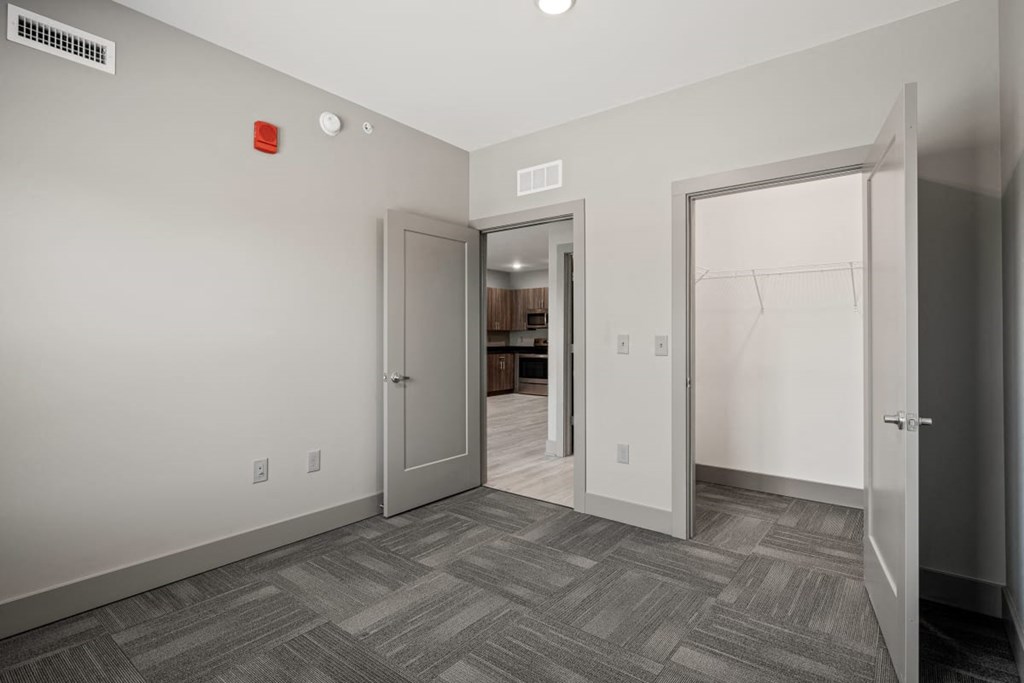 a bedroom with a door to a hallway and a closet