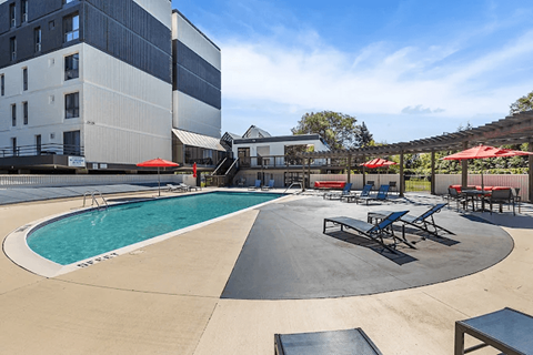 A large outdoor pool area with a slide and seating.