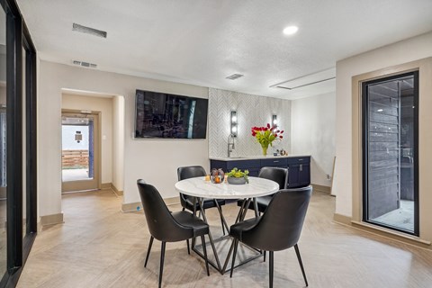 A dining room with a table and chairs.
