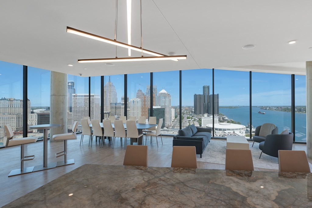 a dining room with a view of a city and a body of water