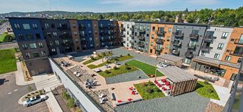 A view of a courtyard with a grassy area and a small garden with red flowers.