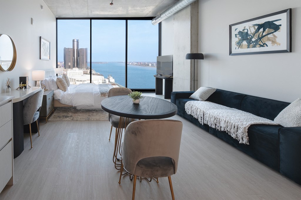 a living room and bedroom with a view of the ocean in a hotel room