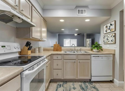 A kitchen with a white stove top oven and a white dishwasher.