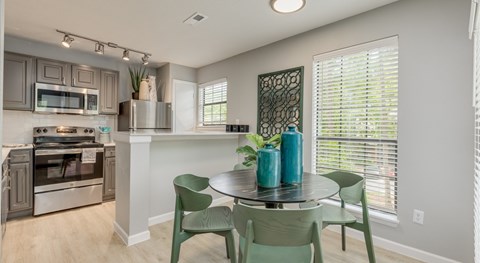 A kitchen with a table and chairs.