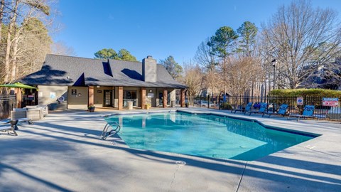 A large swimming pool in front of a house.