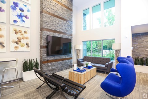A living room with a blue chair and a fireplace.