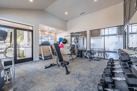 A spacious gym with a variety of equipment including treadmills, weights, and exercise machines.