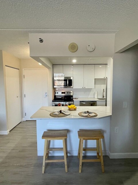 A kitchen with a counter and two stools.