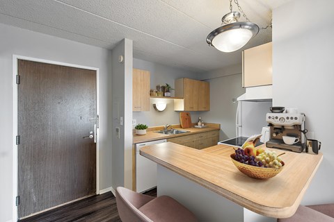 A kitchen with a wooden table and a bowl of fruit on it.