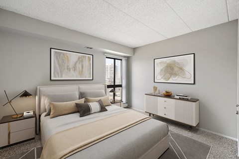 A bedroom with a large bed and a nightstand with a lamp.