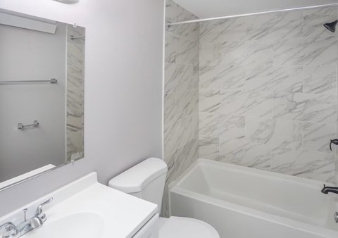 A white toilet sits next to a sink in a bathroom.