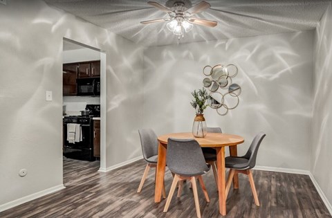A dining room with a wooden table and chairs.