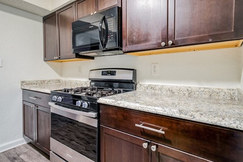 A kitchen with a stove top oven and microwave above it.