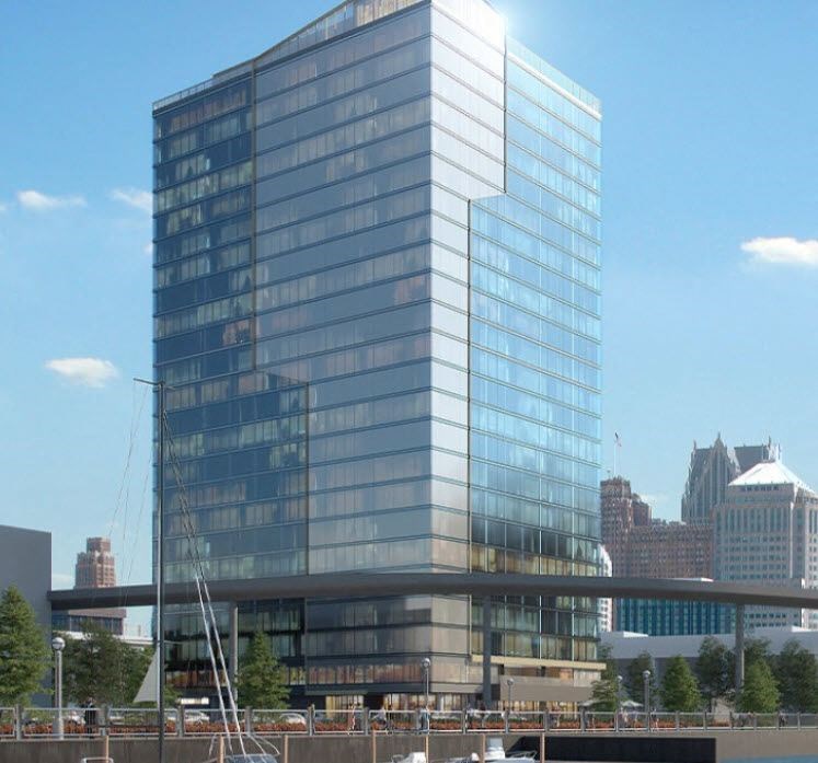 a tall glass building with a bridge in front of it