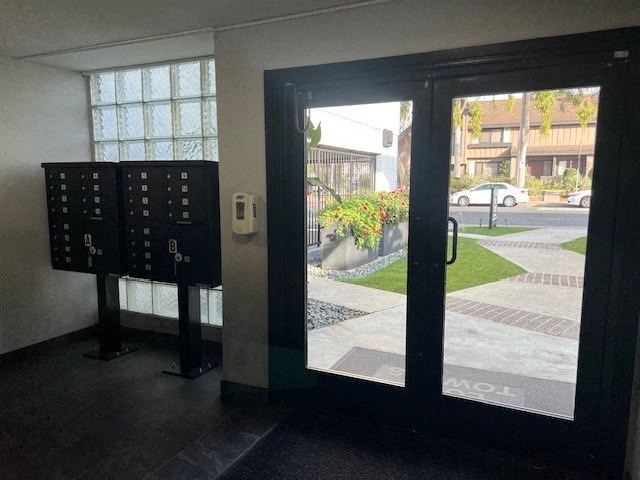 A black door with a glass window showing a street view.