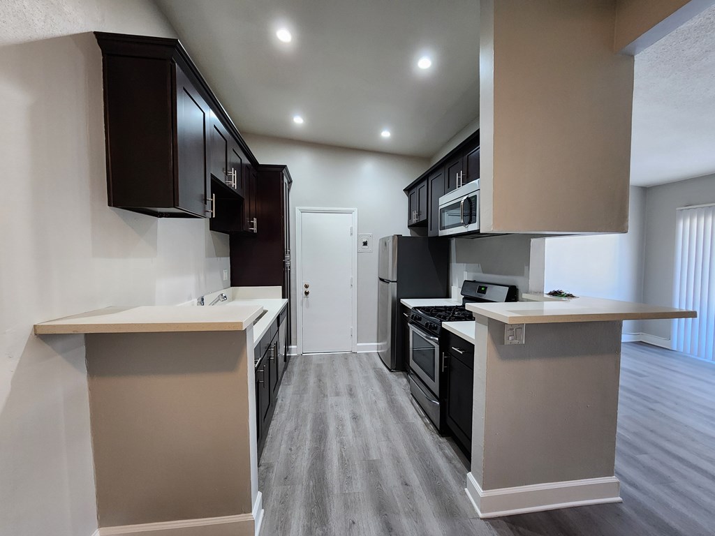 A kitchen with black cabinets and a white countertop.