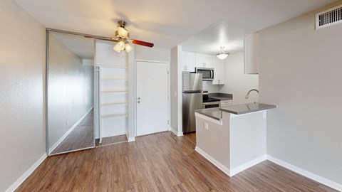 A kitchen area with a refrigerator, microwave, and stove top oven.