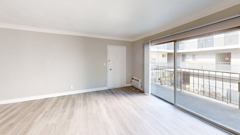 A room with a sliding glass door leading to a balcony.