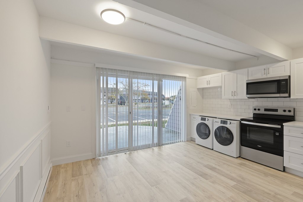 A kitchen with white cabinets and a microwave above the stove.