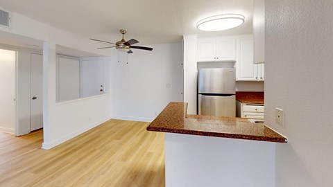 A kitchen with a refrigerator, microwave, and oven.