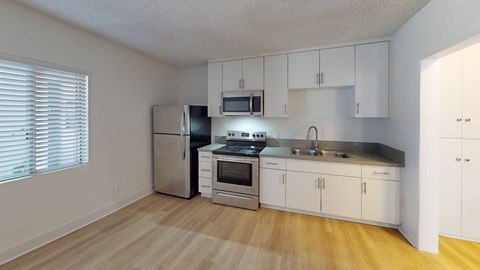 A kitchen with white cabinets and stainless steel appliances.