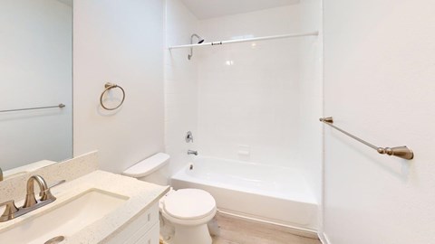 A white bathroom with a toilet, sink, and shower.