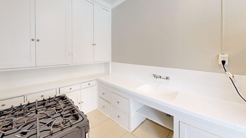 A white kitchen with a stove and cabinets.