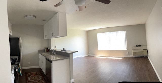 A kitchen with white cabinets and a refrigerator.