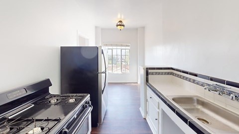 A kitchen with a black stove and a black fridge.