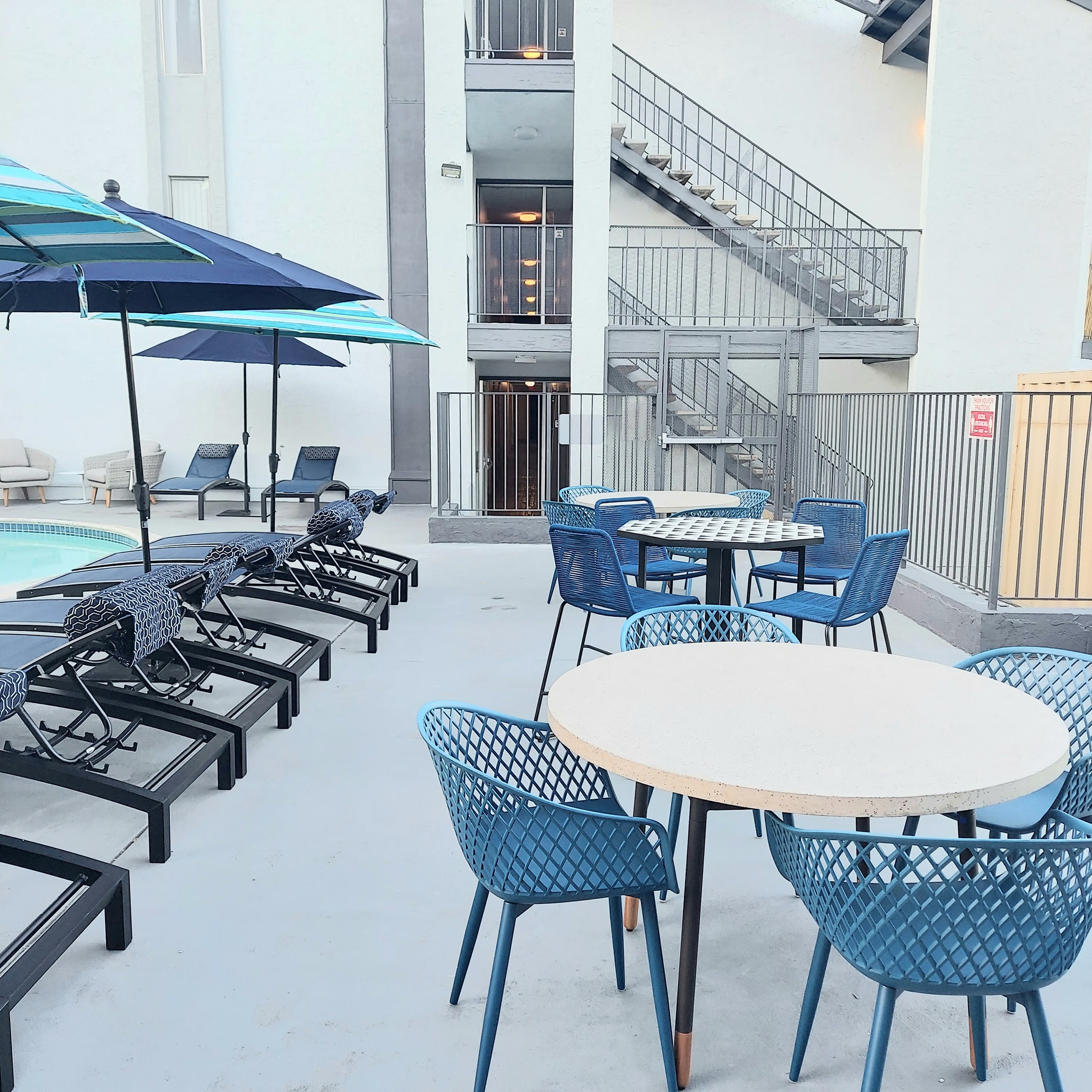 an outdoor area with tables and chairs and a swimming pool