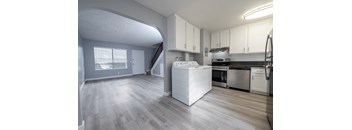 A kitchen with a white dishwasher and stove top oven.