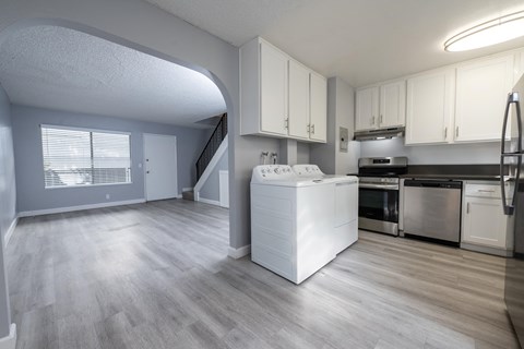 A kitchen with a white dishwasher and stove top oven.