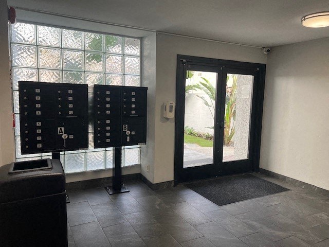 A room with a black door and a black mat on the floor.