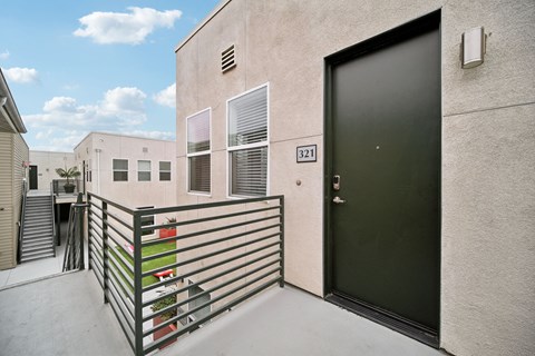 A black door is on the side of a building with a number 321 on it.
