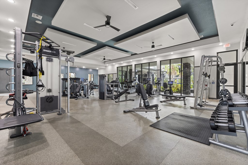 Gym with weights and cardio equipment with glass doors at Pearce at Pavilion Luxury Apartments, Riverview, FL